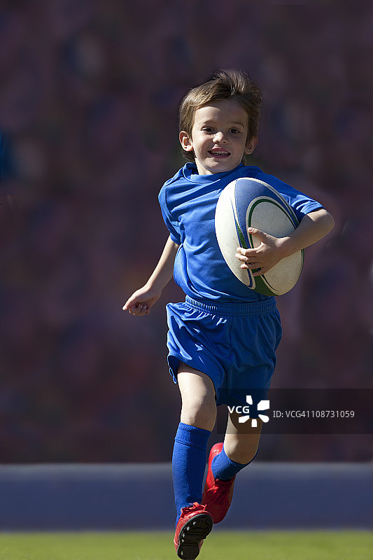 带着球跑的男孩橄榄球运动员图片素材