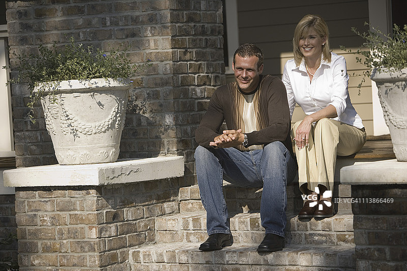 中年夫妇坐在房子前面的台阶上图片素材