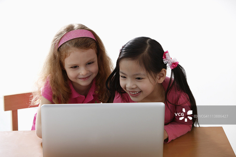 两个小女孩在看笔记本电脑图片素材