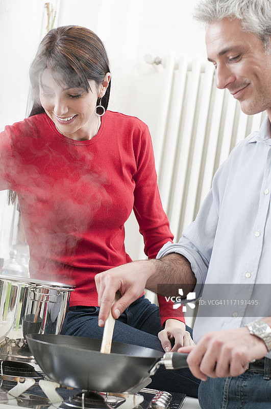 幸福的夫妇在厨房一起做饭图片素材