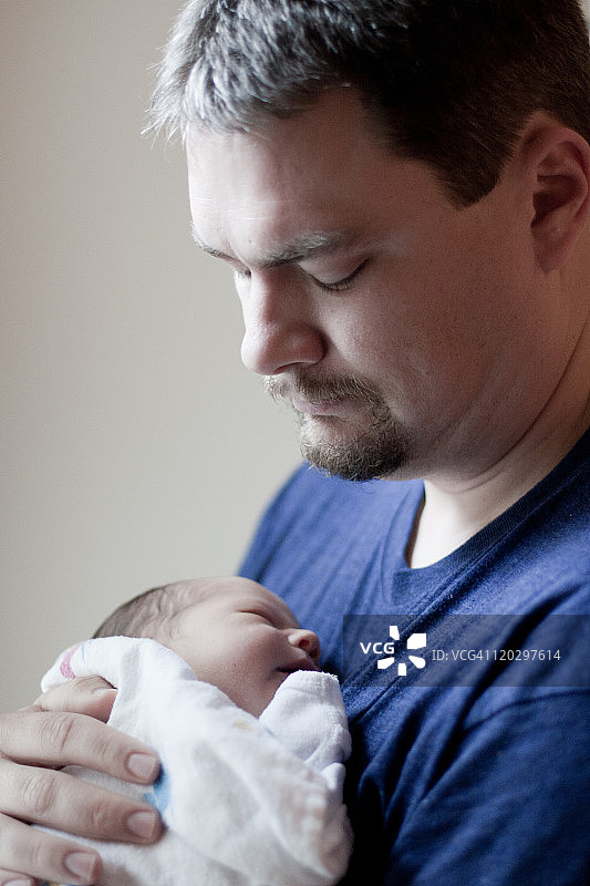 一位父亲第一次抱着他刚出生的儿子图片素材