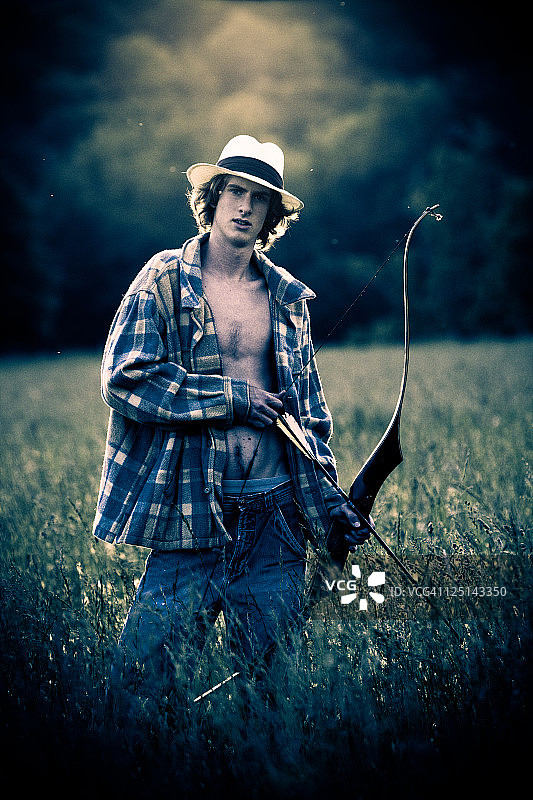 年轻的美国男孩拿着弓和箭的肖像图片素材