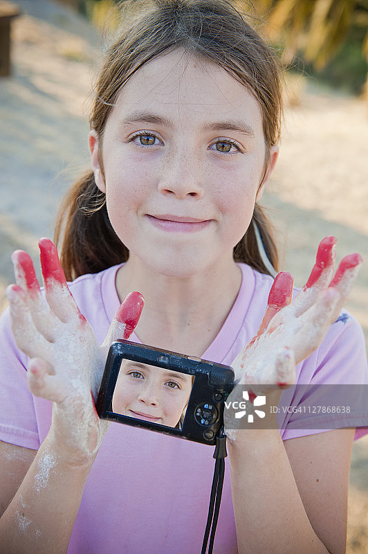 女孩在小相机上展示自画像图片素材