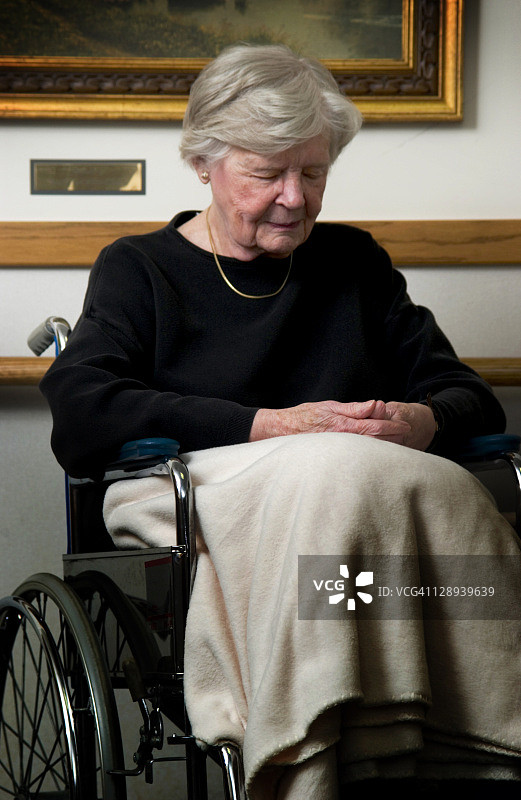 坐在轮椅上祈祷的老妇人图片素材