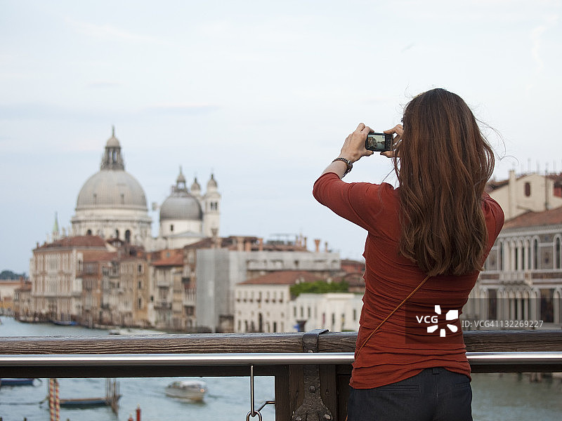 意大利，威尼斯，女人在桥上拍摄建筑图片素材