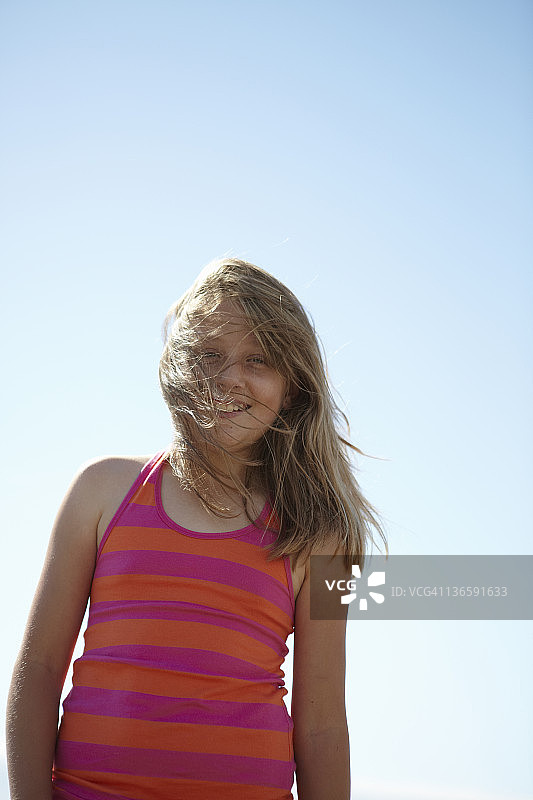 微笑的女孩的头发在风中飘荡图片素材