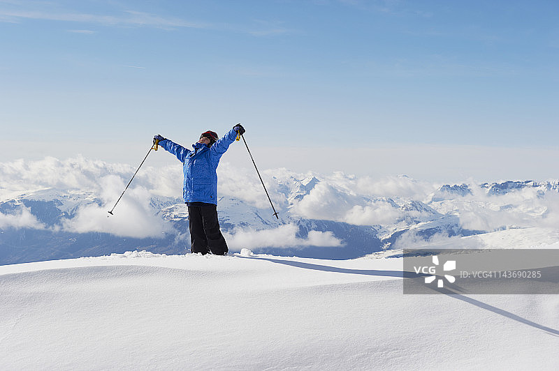 在雪地里抱着滑雪杆的男孩图片素材