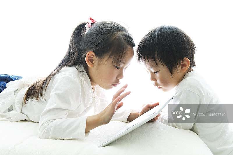 女孩和男孩在用平板电脑图片素材