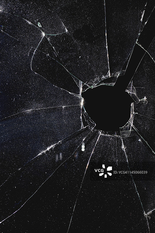 一扇玻璃被打了个洞的窗户，黑夜图片素材