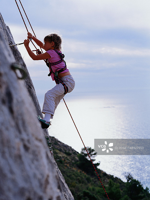 一个女孩在攀岩。图片素材