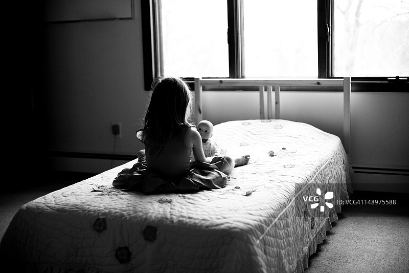 女孩和洋娃娃躺在床上图片素材