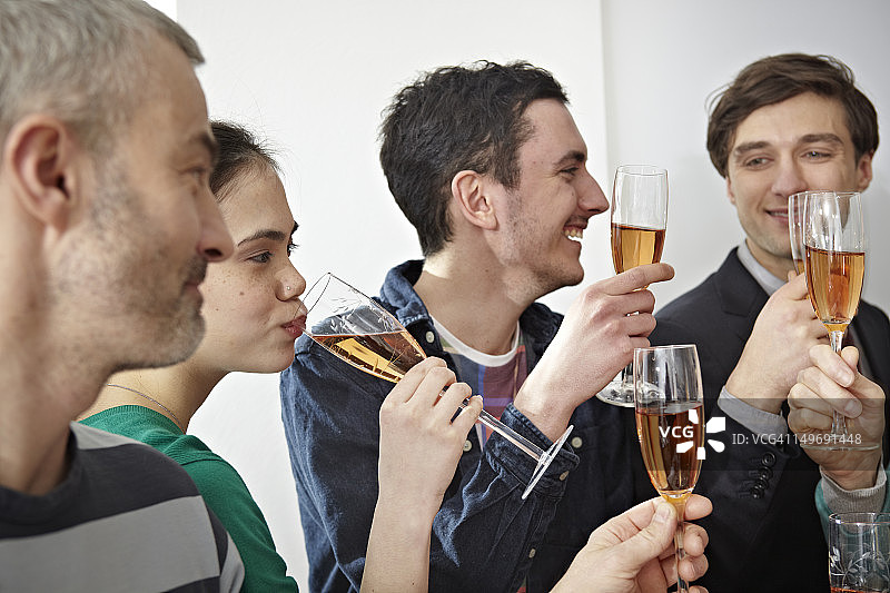 德国，科隆，男男女女在办公室用香槟敬酒图片素材