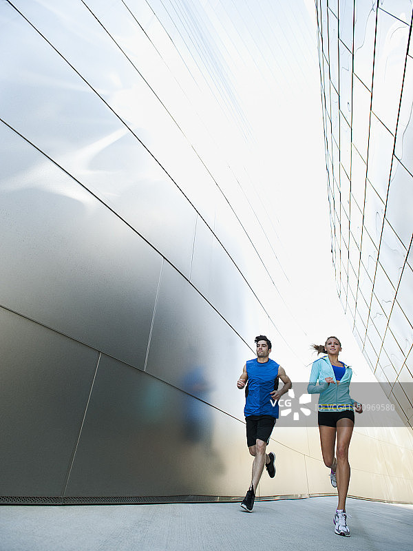 美国，加州，洛杉矶，一对年轻夫妇在城市里慢跑图片素材