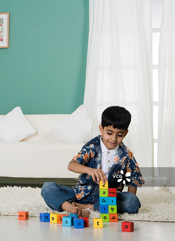 小男孩在客厅玩积木图片素材