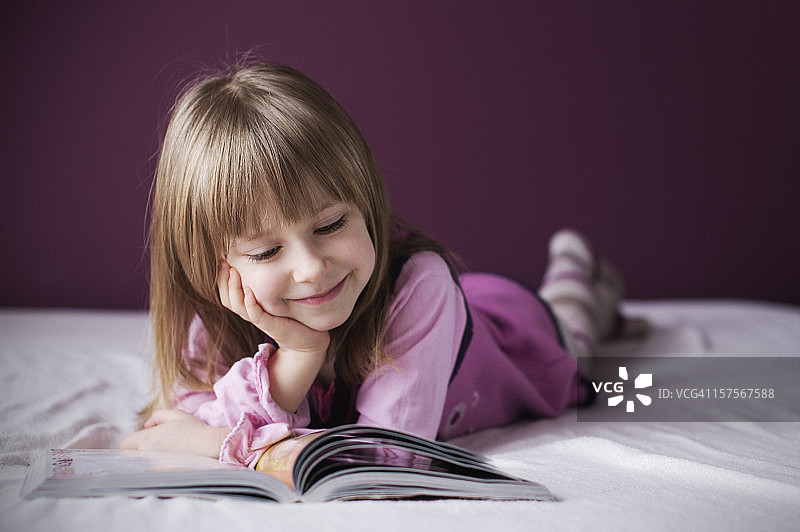 微笑的小女孩在看书图片素材