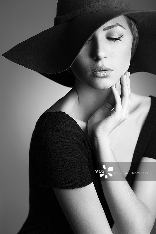 年轻漂亮的女人戴着一顶黑色的帽子图片素材