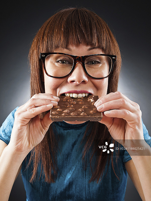 女人吃巧克力的肖像图片素材
