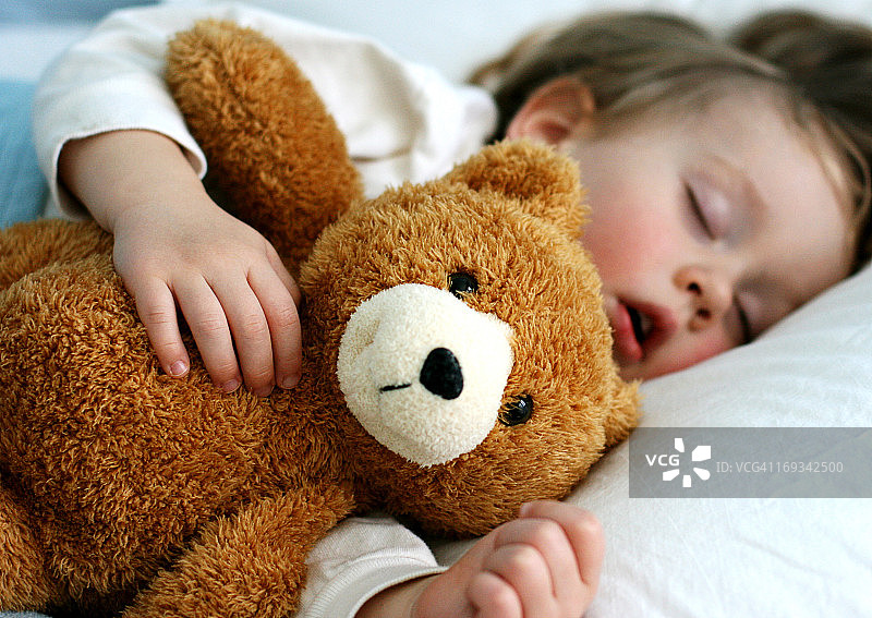 男孩和泰迪熊睡觉图片素材