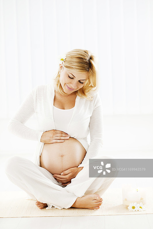 一个孕妇躺在地板上。图片素材