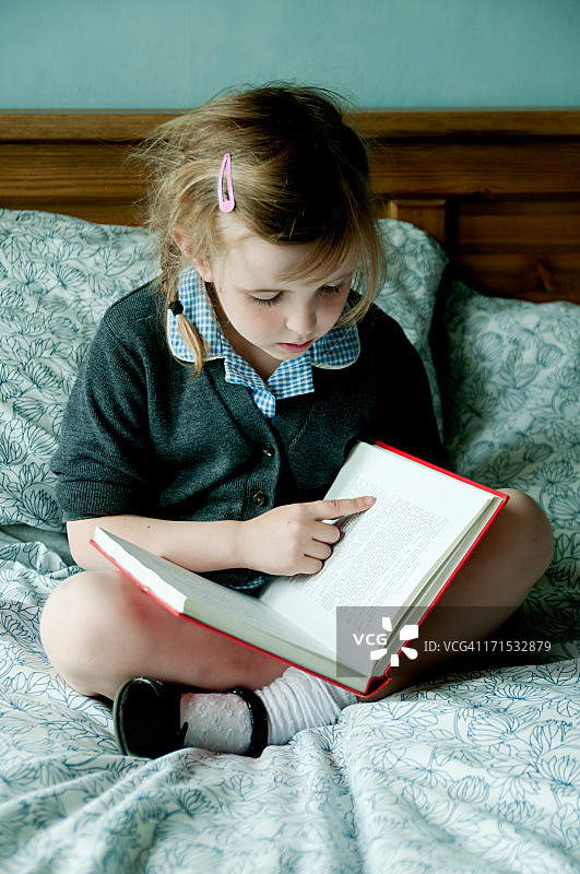 小女孩在床上看书图片素材