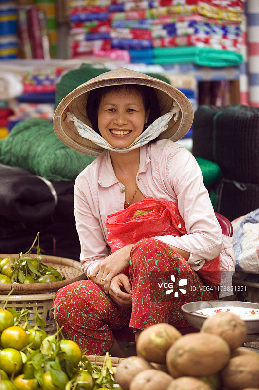 越南妇女在市场上卖蔬菜的照片图片素材