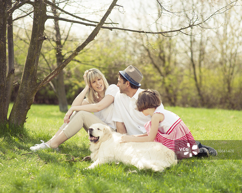 一家人和狗坐在公园里图片素材