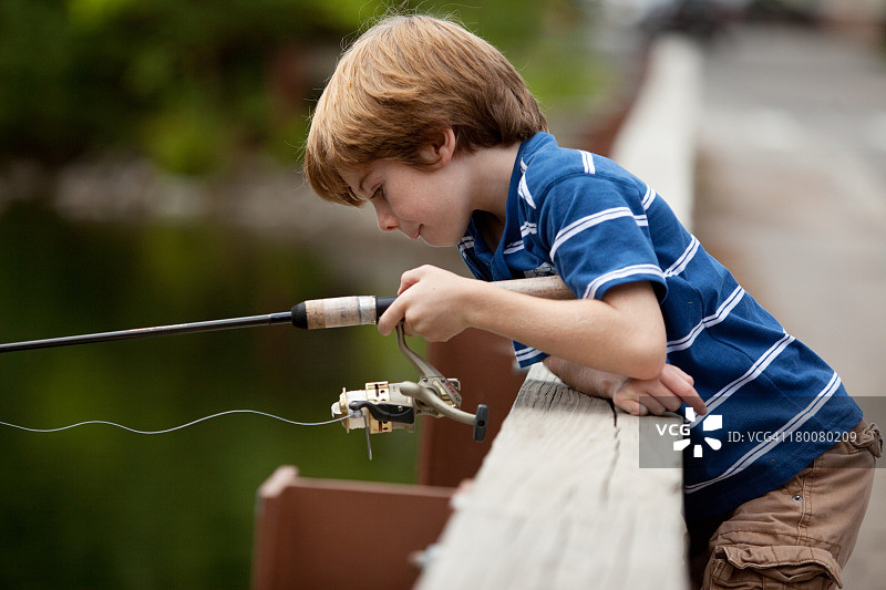 小男孩在桥上钓鱼图片素材