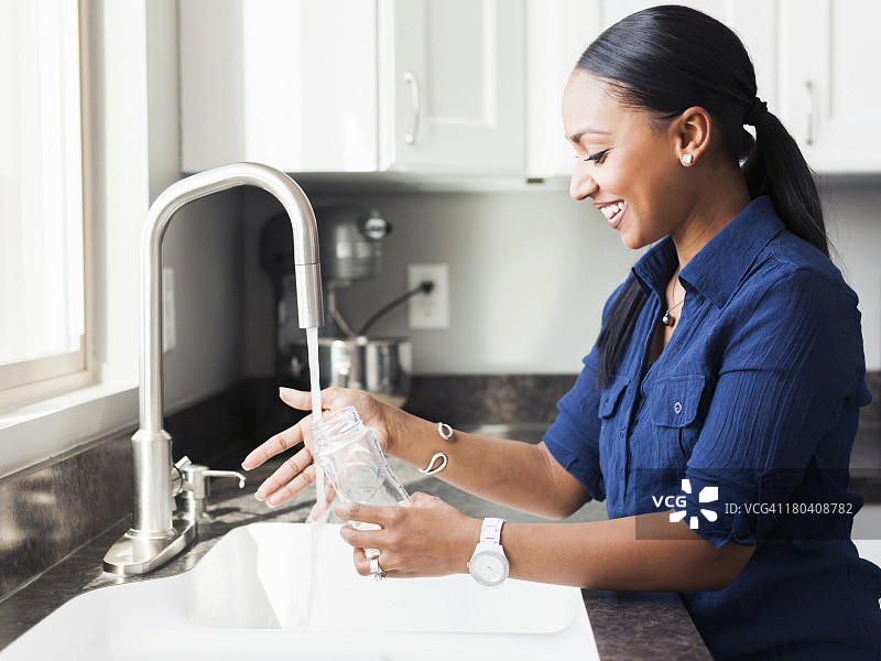 美国，犹他州，Lehi，妇女在厨房里洗婴儿奶瓶图片素材
