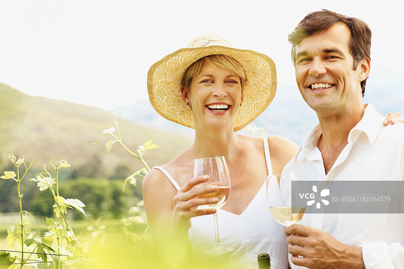 幸福的夫妇在葡萄园里享受美酒图片素材