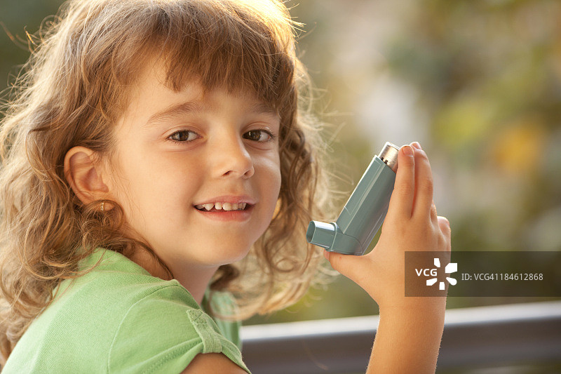 小女孩在室外使用哮喘吸入器图片素材