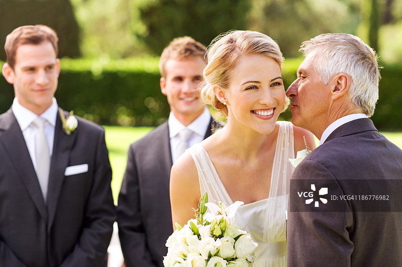 父亲在婚礼上亲吻新娘的脸颊图片素材