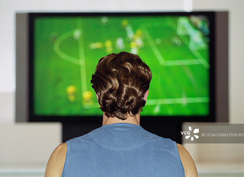 男人在电视上看足球比赛，后视镜图片素材