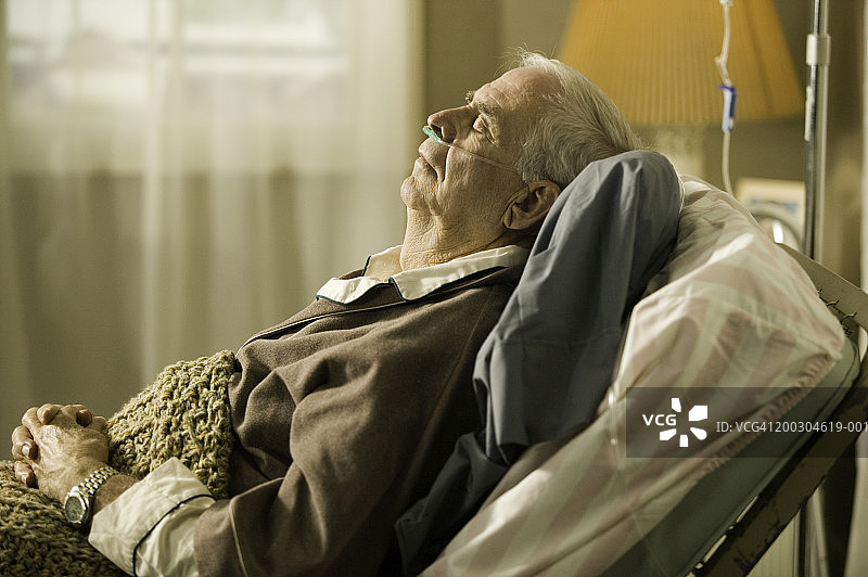 一个老人躺在养老院的床上，鼻子上插着管子图片素材