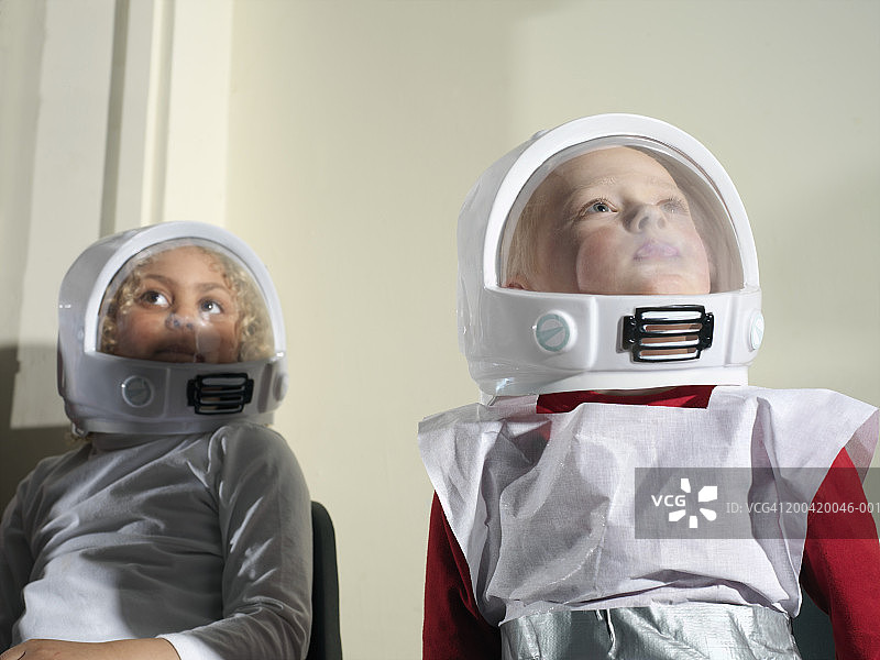 女孩和男孩(5-7)穿着宇航员服装，抬头看，特写图片素材
