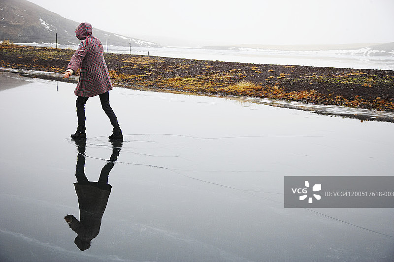 冰岛，女子在结冰的湖面上滑冰图片素材