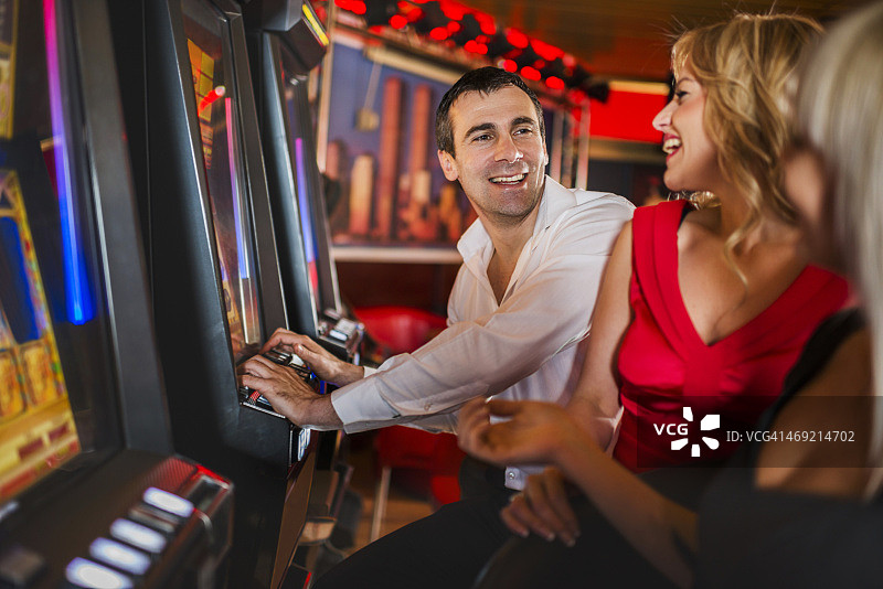 快乐的人们在老虎机上赌博。图片素材