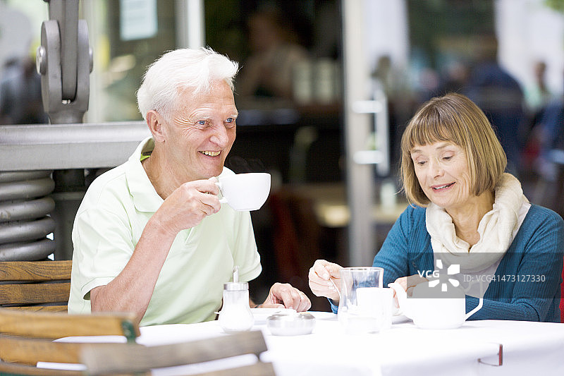 一对老年夫妇微笑着坐在柏林的一家咖啡馆里图片素材