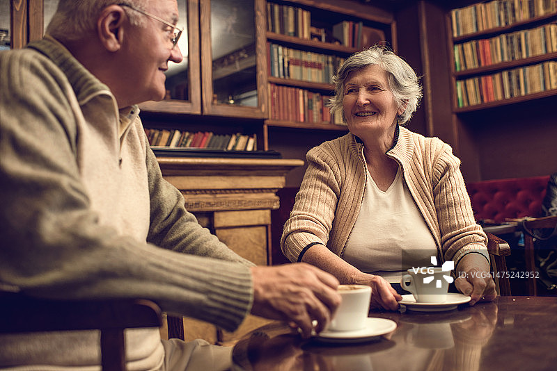 老夫妇在喝咖啡的时间在家里放松和交流。图片素材