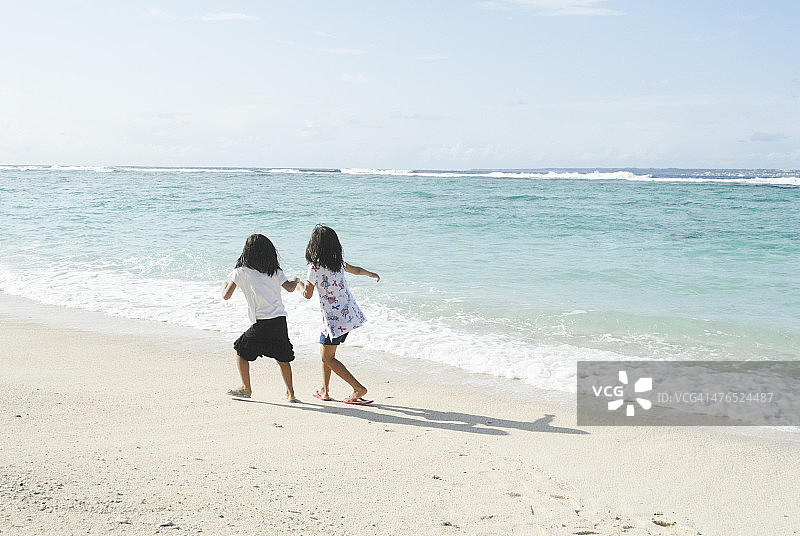 女孩们在沙滩上奔跑图片素材