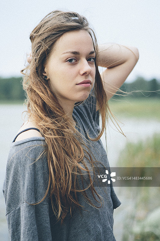 一个年轻的金发女人在湖边的肖像图片素材