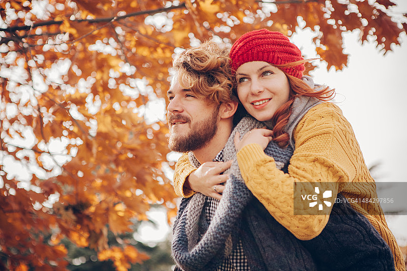 年轻夫妇在公园里享受秋天。图片素材