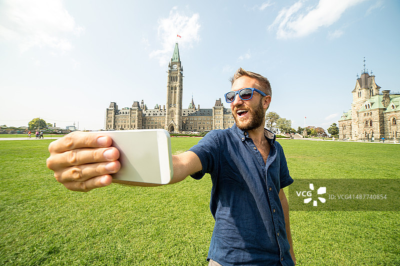 在加拿大渥太华，一个快乐的年轻人正在自拍图片素材