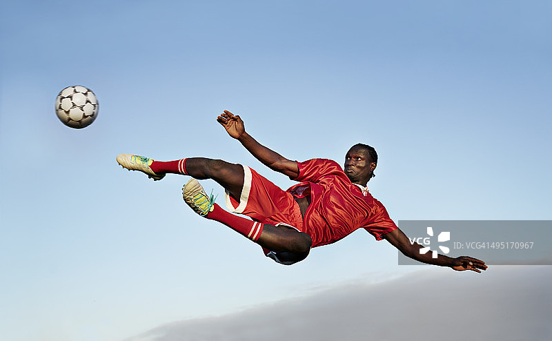 足球运动员正要把球踢向空中图片素材