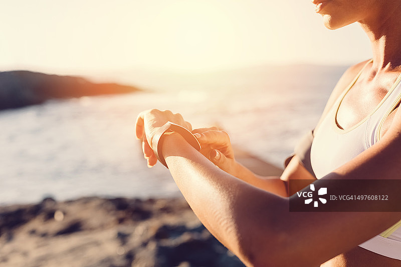 运动女性在海滩上用智能手表图片素材