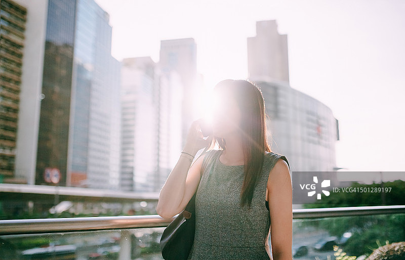 亚洲女商人在城市里用智能手机聊天图片素材
