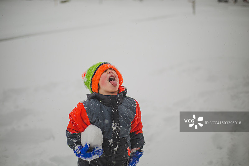 小男孩用舌头接雪花图片素材