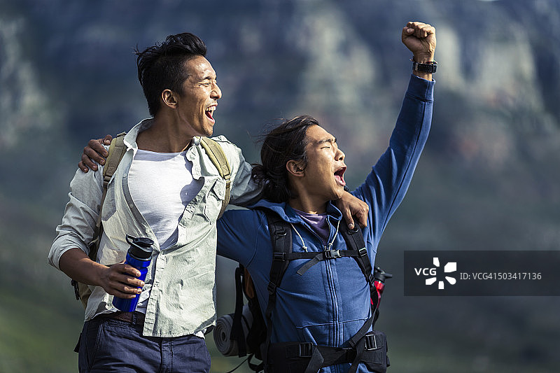 兴奋的男性登山者站在山上图片素材