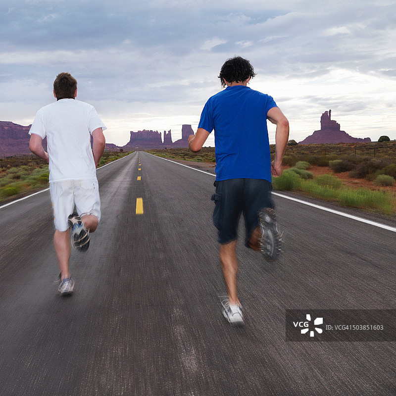 两个人在沙漠路上慢跑图片素材