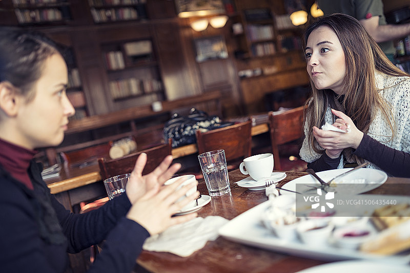 两个年轻女人在餐厅咖啡厅聊天图片素材