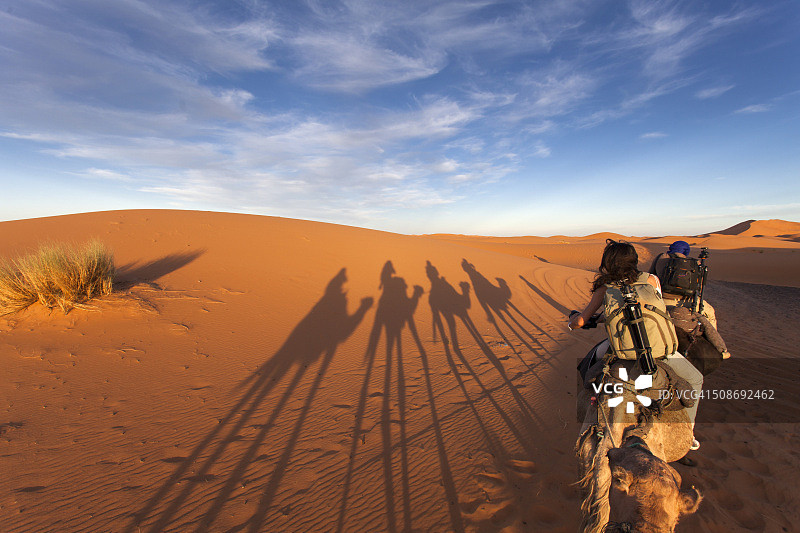 一群在沙漠中与古老的游牧民族进行骆驼旅行的游客图片素材